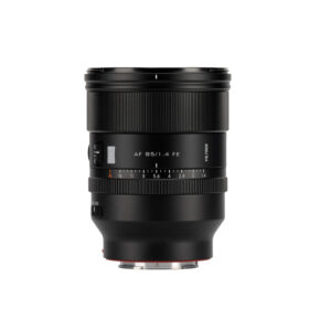 1747829475_875 Musta Viltrox AF 85mm F/1.4 -objektiivi Sony FE:lle, jossa on tarkennusrengas ja aukkomerkinnät, piipussa merkintä "AF 85/1.4 FE", seisoo pystyssä valkoista taustaa vasten.