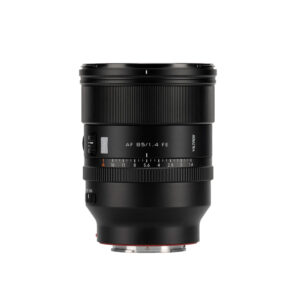 1747829475_875 Musta Viltrox AF 85mm F/1.4 -objektiivi Sony FE:lle, jossa on tarkennusrengas ja aukkomerkinnät, piipussa merkintä "AF 85/1.4 FE", seisoo pystyssä valkoista taustaa vasten.