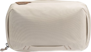 800q-01_123340 Peak Design Tech Pouch // Bone on beige suorakulmainen kangaspussi, jossa on vasemmanpuoleinen vetoketju, pieni ruskea lappu vasemmassa yläkulmassa ja hienovaraiset tikkaukset lähellä pohjaa.