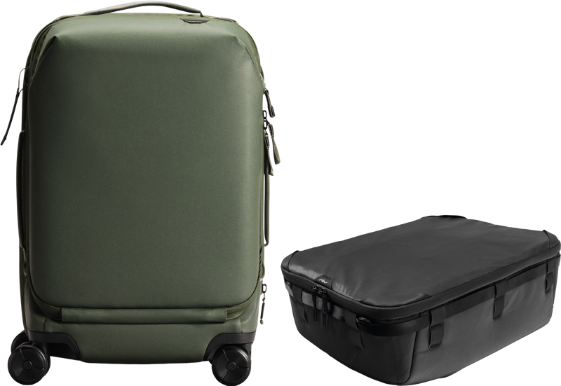 800q-01_133332 Vihreä Peak Design Roller Pro Carry-On seisoo pystyssä mustan Camera Cube V2 X-large -kamerakuution vieressä, ja molemmat on sijoitettu vaalealle taustalle.