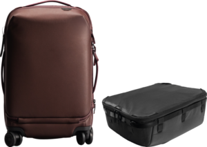 Punainen Peak Design Roller Pro Carry-On on pystyssä X-suuren Camera Cube V2 -kamerakuution vieressä, molemmat valkoisella pohjalla.