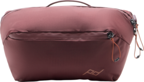 Peak Design Outdoor Sling 4L Eclipse on ruskeankeltainen, suorakulmainen matkapussi, jossa on vetoketju, pieni kantokahva ja hienovarainen PD-logo oikeassa alakulmassa.