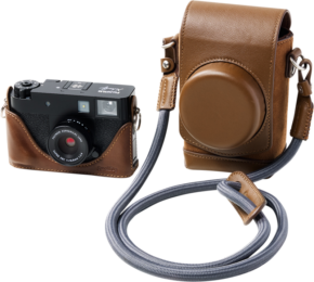 800q-01_133471 SmallRig 5218 Leather Case Kit for Fujifilm X in Half Brown -kotelosarjassa on kuvassa musta kompaktikamera, joka on asennettu ruskeaan nahkakotelon puolikkaaseen, sekä yhteensopiva ruskea nahkakamerakotelo, jossa on olkahihna, valkoisella pohjalla.
