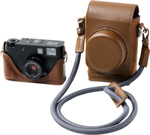 800q-01_133471 SmallRig 5218 Leather Case Kit for Fujifilm X in Half Brown -kotelosarjassa on kuvassa musta kompaktikamera, joka on asennettu ruskeaan nahkakotelon puolikkaaseen, sekä yhteensopiva ruskea nahkakamerakotelo, jossa on olkahihna, valkoisella pohjalla.