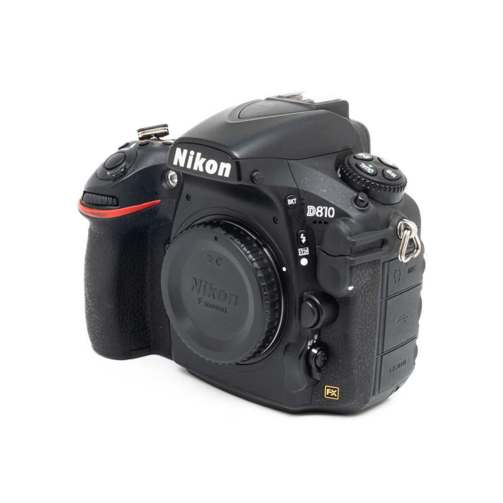 Nikon D810-5-2 A Nikon D810 (sis. ALV 25,5%, SC 46000) - Käytetty, musta runko, kuvattuna oikealta viistosta, objektiivin suojakansi ja useita säätöpainikkeita näkyvissä.