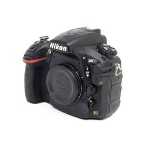 Nikon D810-5-2 A Nikon D810 (sis. ALV 25,5%, SC 46000) - Käytetty, musta runko, kuvattuna oikealta viistosta, objektiivin suojakansi ja useita säätöpainikkeita näkyvissä.