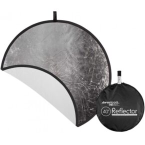 1535096604_109 Westcott Collapsible 2-in-1 Silver/White Bounce Reflector (102 cm) on kuvassa osittain avattuna, jolloin sen hopeanväriset ja valkoiset sivut näkyvät, ja sen vieressä on vetoketjullinen kantolaukku.