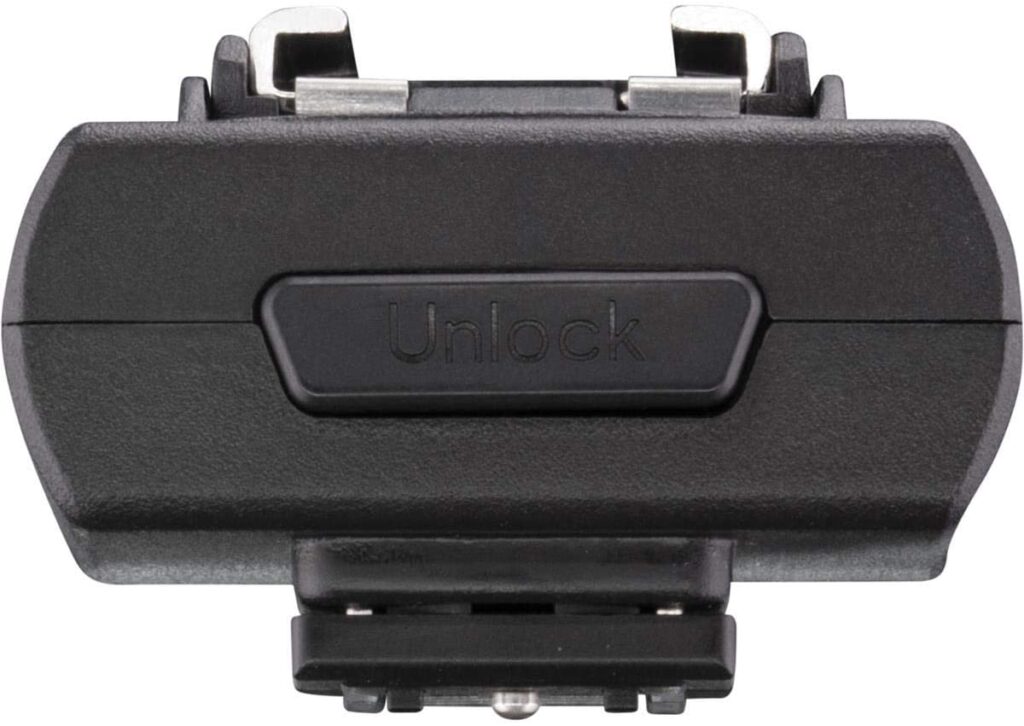 1644397549_263 Etupuolen lähikuva Westcott FJ Wireless Adapter for Sony -kameran mustasta lisävarusteesta, jossa on metalliset liittimet ja keskellä painike, jossa lukituksen avaus, valkoista taustaa vasten.