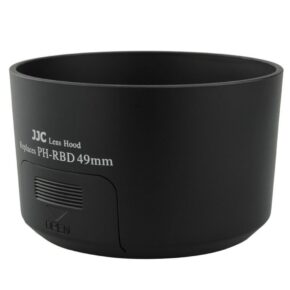 Mustassa JJC PH RBD Pentax -vastavalosuoja 49 mm:n linssinsuojuksessa on "Replaces PH-RBD 49mm" ja sen kyljessä OPEN-ilmaisin alaspäin osoittavalla nuolella.