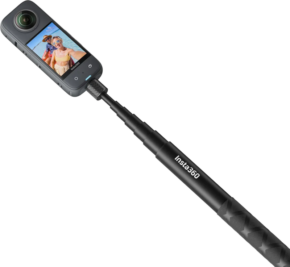800q-01_133590 Insta360 114cm Invisible Selfie Stick mustassa värissä, johon on kiinnitetty 360 asteen toimintakamera, näyttää kaksi hymyilevää ihmistä näytöllään rannalla.