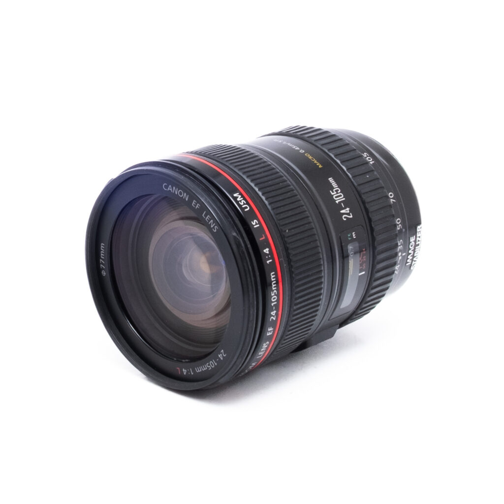 Canon 24-105 f4 L IS USM VVS-2 Canon EF 24-105mm f/4 L IS USM - Käytetty -objektiivi näkyy valkoisella pohjalla, ja sen punainen rengas, zoomaus- ja tarkennusrenkaat sekä näkyvät polttovälimerkinnät korostuvat.