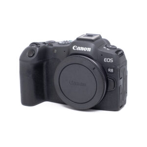 Canon EOS R8-1 Canon EOS R8 (Kunto K5, Shuttercount 1000, Takuu 24kk) - Käytetty näkyy vinossa valkoisella taustalla, ja objektiivin kiinnitys on suojattu suojakorkilla.