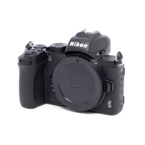 Nikon Z50-1 Nikon Z50 (SC 300, Kunto K5) - Käytetty runko on esitetty mustana valkoisella pohjalla ilman objektiivia, ja etupuolella olevat säätimet, painikkeet ja mallinimi on korostettu.