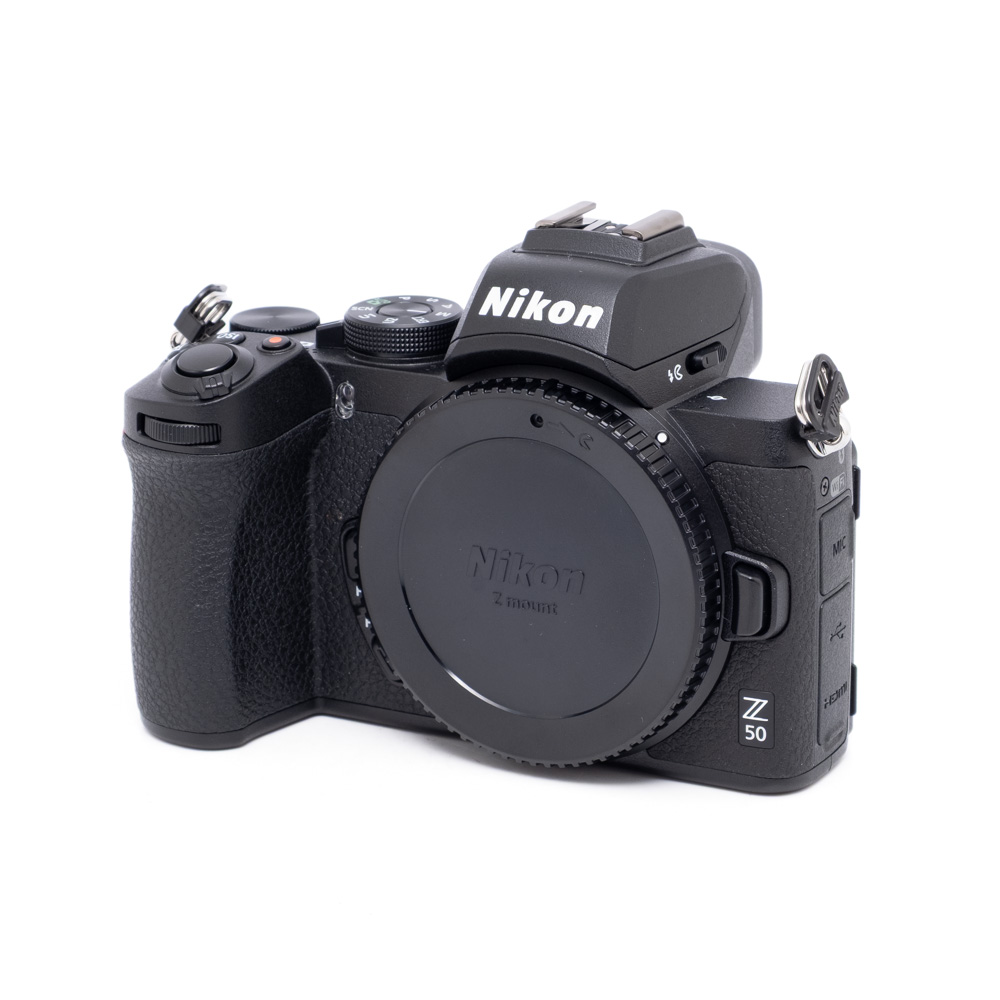 Nikon Z50-1 Nikon Z50 (SC 300, Kunto K5) - Käytetty runko on esitetty mustana valkoisella pohjalla ilman objektiivia, ja etupuolella olevat säätimet, painikkeet ja mallinimi on korostettu.