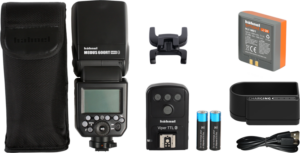Hähnel Modus 600RT MK II Wireless Kit Nikon -salamakitti sisältää salamalaitteen, kantolaukun, salamajalustan, langattoman laukaisimen, kaksi AA-akkua, kameran akun, laturin ja kaapelin, jotka on järjestetty valkoiselle taustalle.