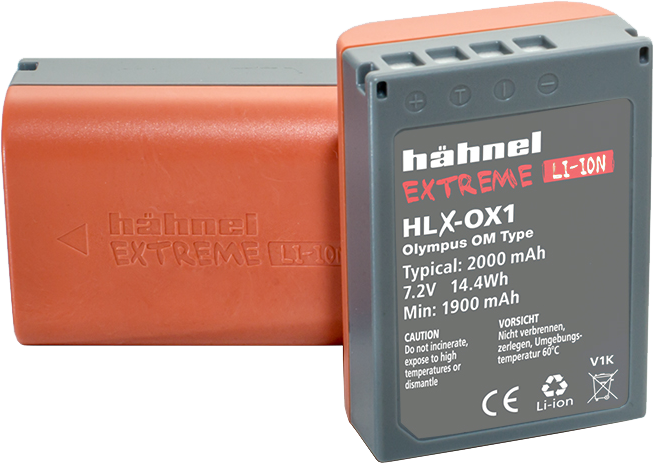 800q-01_120870 Kuvassa on kaksi harmaata ja oranssia Hähnel Battery Extreme Olympus HLX-OX1 / BLX-1 -akkuakkua: toinen on pystyssä ja näyttää etikettinsä ja tekniset tiedot, kun taas toinen makaa litteänä taustalla.