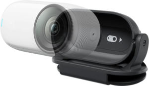 800q-01_133920 Insta360 GO 3/GO 3S Easy Clipin lähikuvassa näkyy sen tyylikäs ja kompakti muotoilu, jossa liukuva suojakansi on osittain auki, jolloin kameran linssi ja liukukytkin paljastuvat, ja kaikki on kiinnitetty tukevasti pidikkeeseen.
