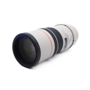 Canon 300mm f4 L IS-2 Canon EF 300mm f/4 L IS USM (Kunto K5, Takuuta 6kk) - Käytetty on valkoinen teleobjektiivi, jossa on musta tarkennusrengas ja punainen aksentti, joka näkyy valkoisella pinnalla korostaen etulasin ja piipun yksityiskohtia.