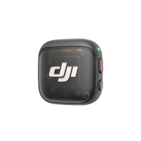 DJIMIC3Transm DJI Mic 3 Transmitter -lähetin on kompakti, musta langaton lähetin, jossa on pyöristetyt reunat, virtanäppäin sivulla ja pieni vihreä merkkivalo yläkulmassa.