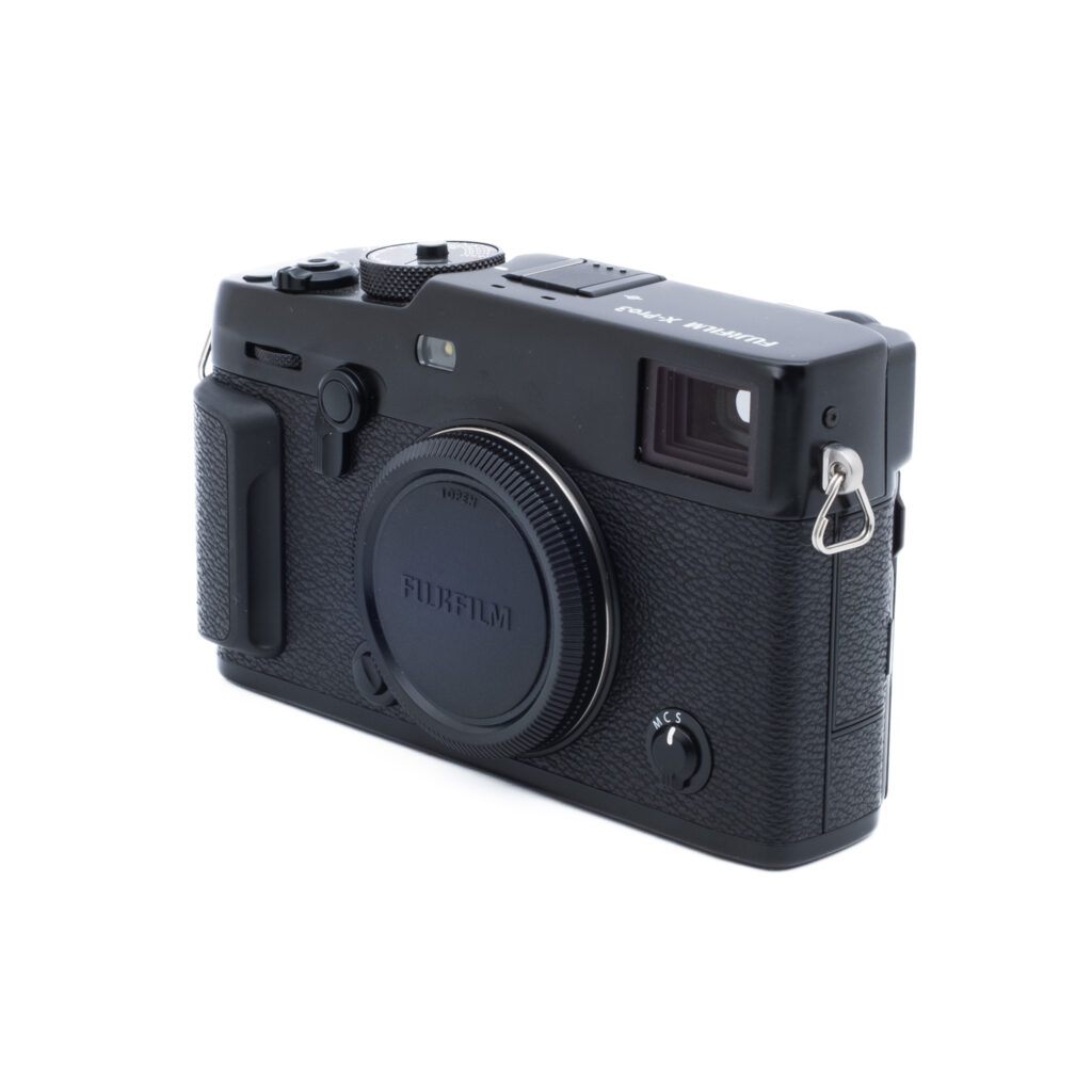 Fuji XPro 3-5 Musta Fujifilm X-Pro3 (SC 100, Kunto K5) - Käytetty digitaalikamera, jossa on kuvioitu kahva, objektiivin suojus kiinnitettynä ja erilaisia säätimiä valkoisella taustalla.