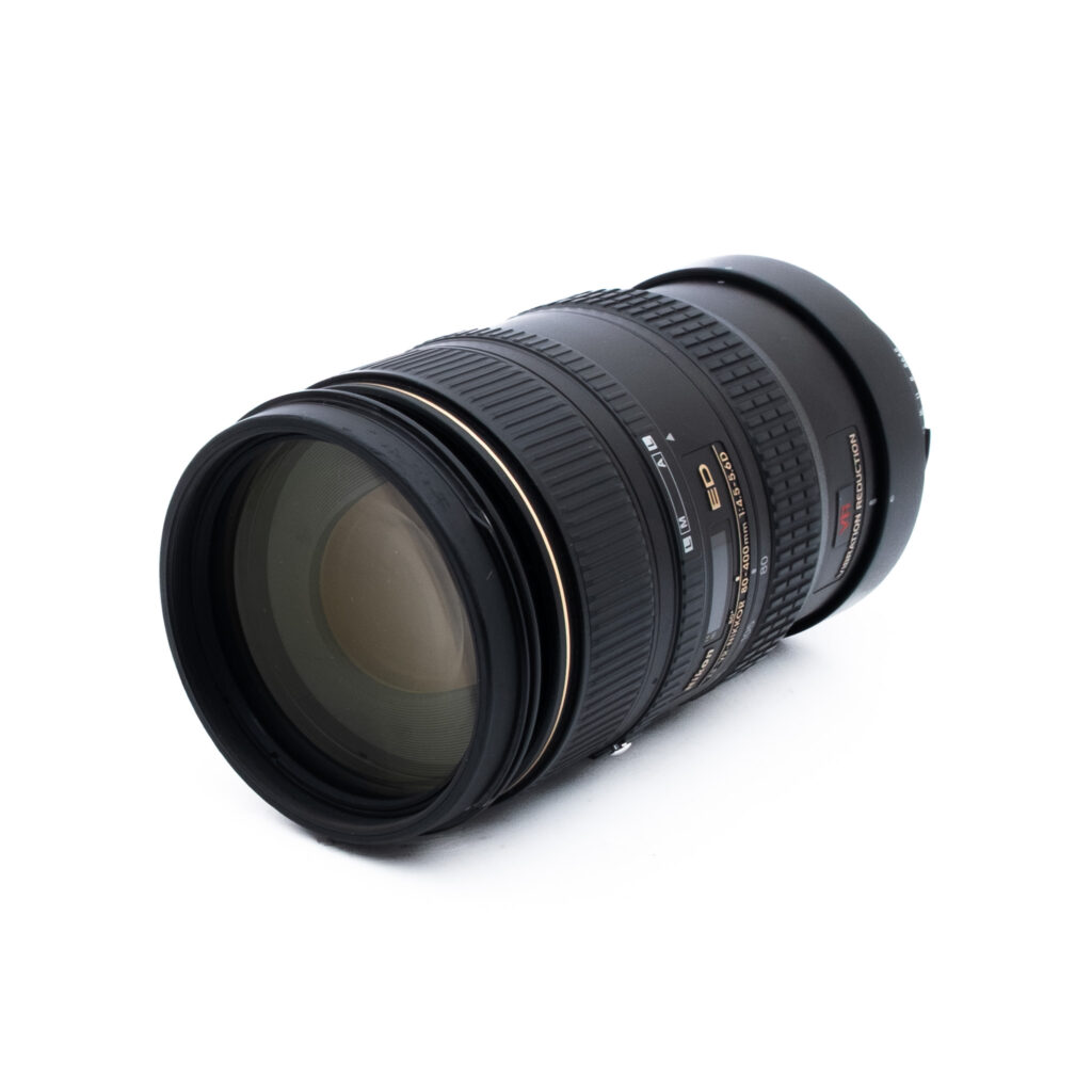 Nikon 80-400-2 Nikon AF VR Zoom-Nikkor 80-400mm f/4.5-5.6D ED - Käytetty -objektiivi, jossa on kultaiset ja valkoiset merkinnät, näkyy valkoisella taustalla, ja sekä lasielementti että objektiivin runko näkyvät selvästi.