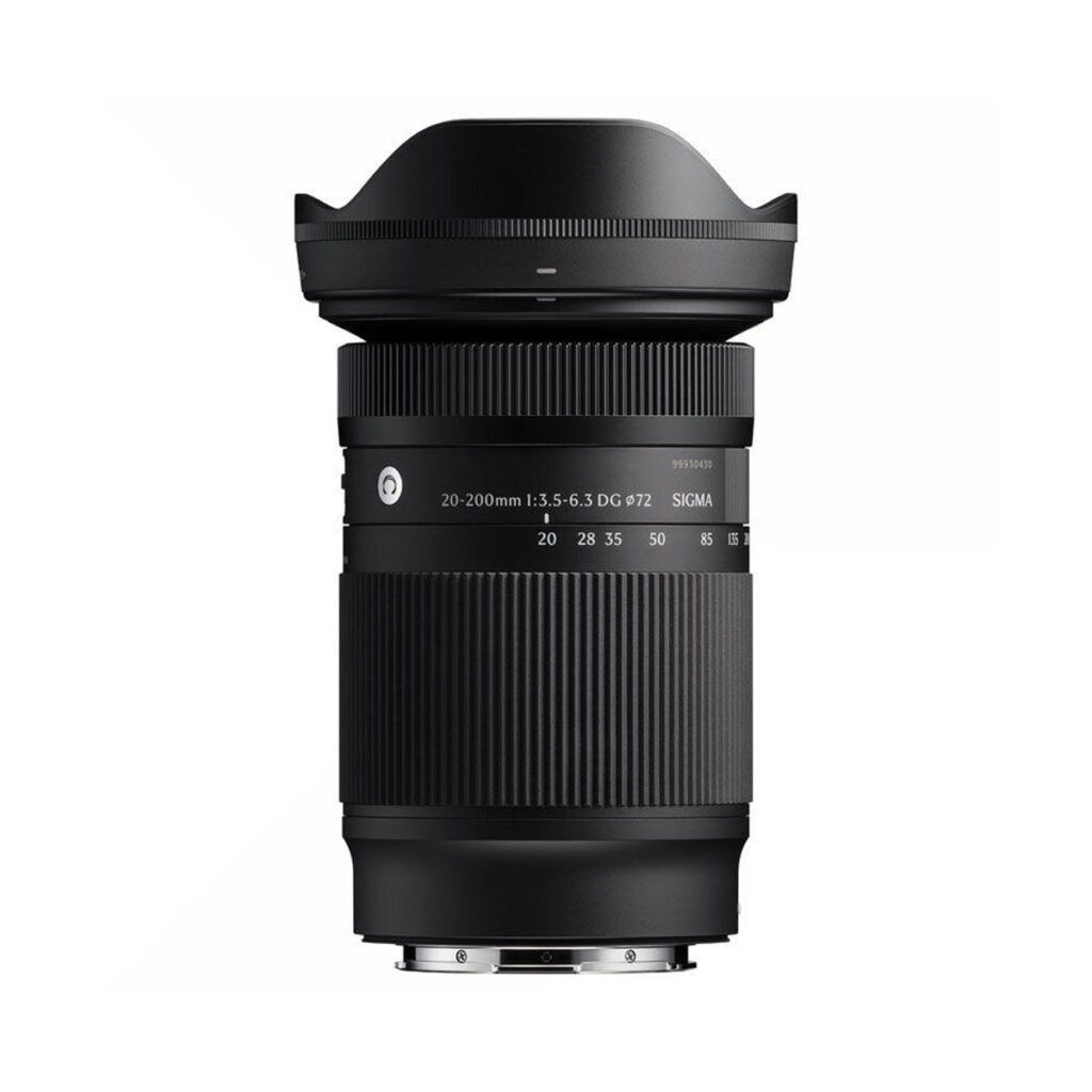 Sigma20-200mm Musta Sigma 20-200mm f/3.5-6.3 DG Contemporary L-Mount -objektiivi seisoo pystysuorassa valkoista taustaa vasten, ja siinä on uurrettu zoomausrengas ja terälehden muotoinen huppu.