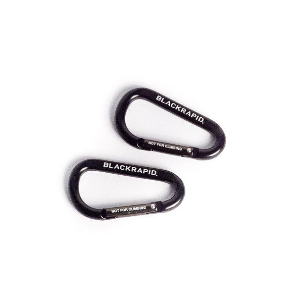 1597325604_972 Kaksi mustaa BlackRapid CarabineR (2 kpl) -karabinettia, joissa on merkinnät "BLACKRAPID" ja "NOT FOR CLIMBING", lepäävät samansuuntaisesti valkoisella pinnalla.