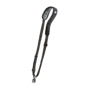 © BryCox.com, Bry Cox BlackRapid RS W2 Camera Sling for Women -kamerahihna on musta säädettävä hihna, jossa on pehmustettu olkaosa ja metalliklipsi, joka näkyy valkoisella pohjalla.