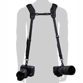 Siluetti henkilöstä, jolla on BlackRapid Blackline II Double Camera Harness -kamerahihna ja joka kantaa kahta mustaa DSLR-kameraa lantion korkeudella, yksi kummallakin puolella.