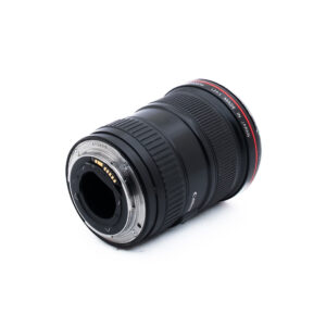 Canon 16-35mm f28 L USM-1 Canon-kameran objektiivi kyljellään, jossa näkyy metallinen kiinnitysrengas ja elektroniset koskettimet. Objektiivi on musta, ja sen etupuolella on punainen rengas ja valkoinen teksti, jossa on sen tekniset tiedot. Tausta on valkoinen.