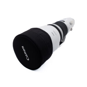 Canon 400mm f28 L IS II USM-4 Suuri Canon-telekameran objektiivi, jossa on musta suojakotelo, kuvattuna kulmassa valkoisella taustalla. Objektiivi on valkoinen mustilla korostuksilla, ja siinä on näkyvissä ohjauskytkimet ja tuotemerkki.