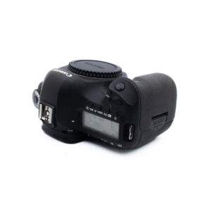 Canon 5D Mark III-2 Mustan Canon DSLR-kameran runko on kuvattu ylhäältä päin, ja siinä näkyvät ohjauspainikkeet, LCD-näyttö ja kuvioitu kahva. Objektiivia ei ole kiinnitetty. Tausta on valkoinen.