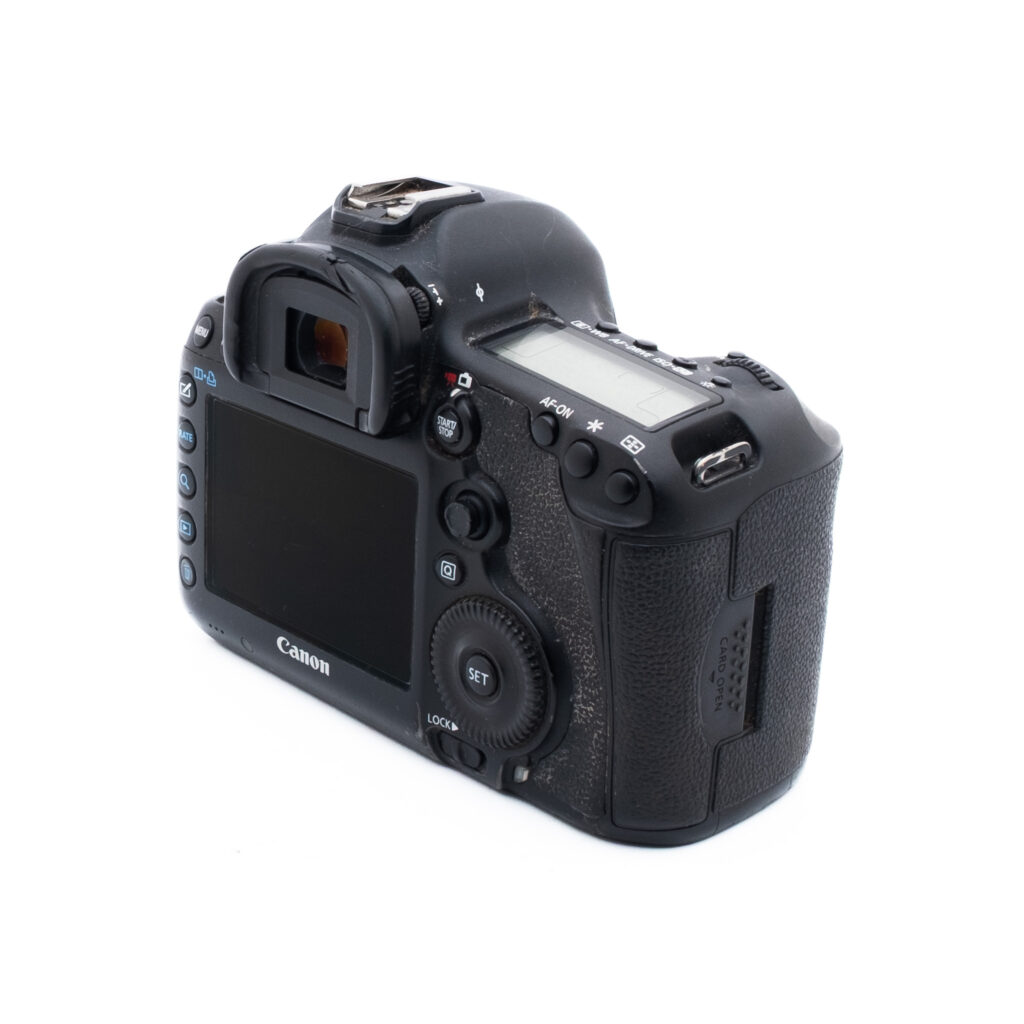 Canon 5D Mark III-3 Musta Canon DSLR-kamera takaapäin ja vasemmalta puolelta näytöllä, painikkeilla, säätimillä ja kuvioidulla kahvalla valkoista taustaa vasten.