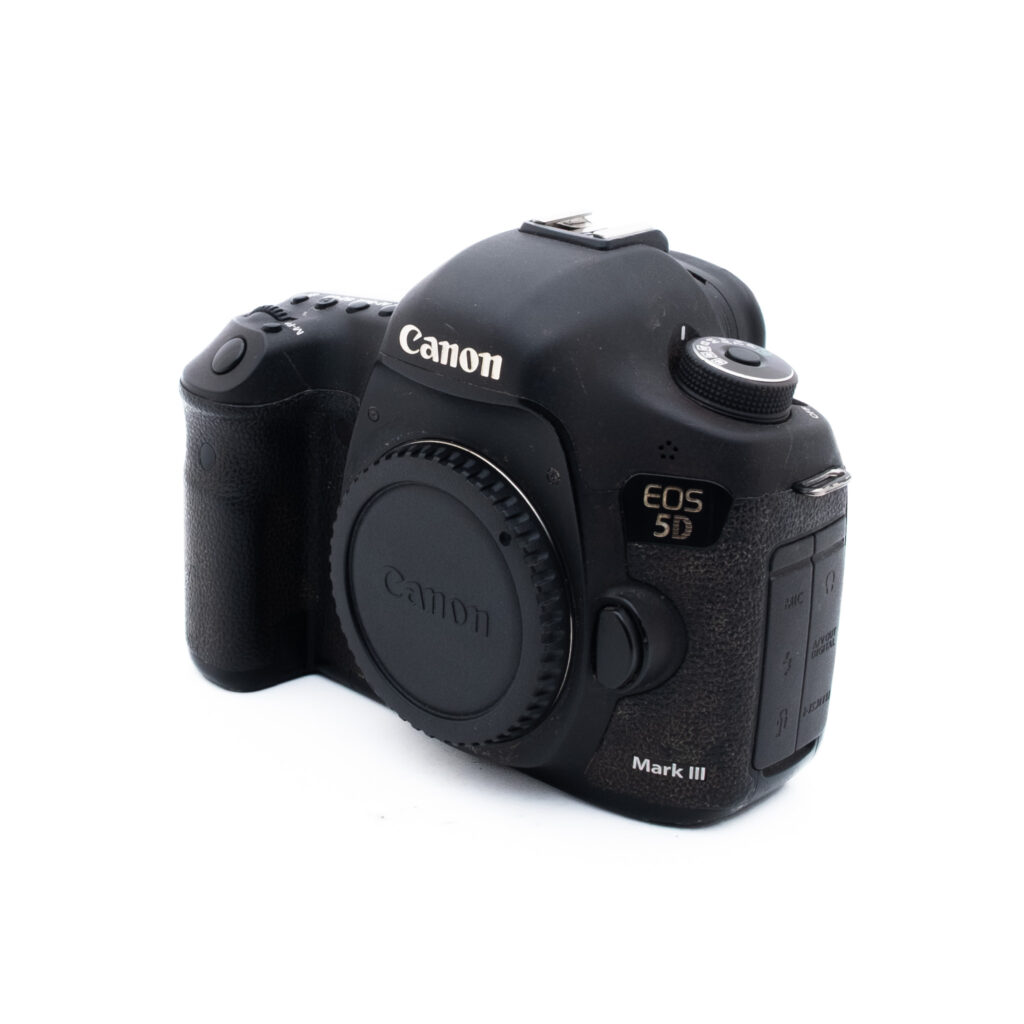 Canon 5D Mark III-5 Musta Canon EOS 5D Mark III DSLR-kameran runko näkyy valkoista taustaa vasten vinosta etuperspektiivistä ilman kiinnitettyä objektiivia.