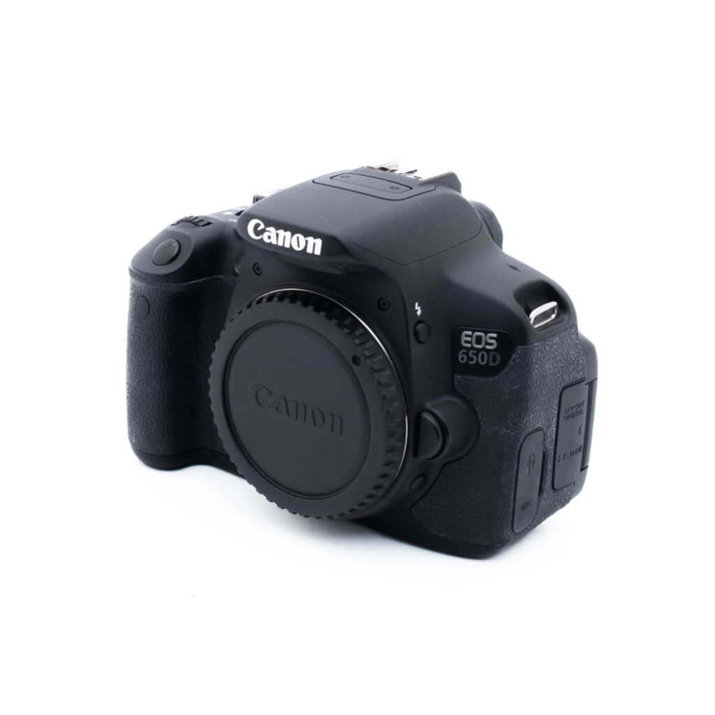Canon 650D 4590-5 Musta Canon EOS 650D -digitaalikameran runko on kuvattu kulmassa valkoisella taustalla ilman kiinnitettyä objektiivia. Kamerassa on kuvioitu kahva ja sivulla näkyvät ohjauspainikkeet.