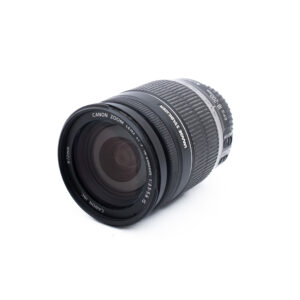 Canon Zoom-objektiivi EF-S 18-55mm f/3.5-5.6 on sijoitettu valkoiselle taustalle, hieman vasemmalle kallistettuna, jolloin etulasi ja zoom-merkinnät näkyvät.