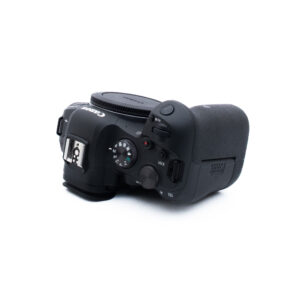 Canon R6 3546-2 Musta Canon DSLR-kameran runko näkyy valkoisella pohjalla, ja se on käännetty niin, että sen yläosan säätimet, kuten toimintatilan valitsin, suljinpainike ja kameran kengän kiinnitys, näkyvät.