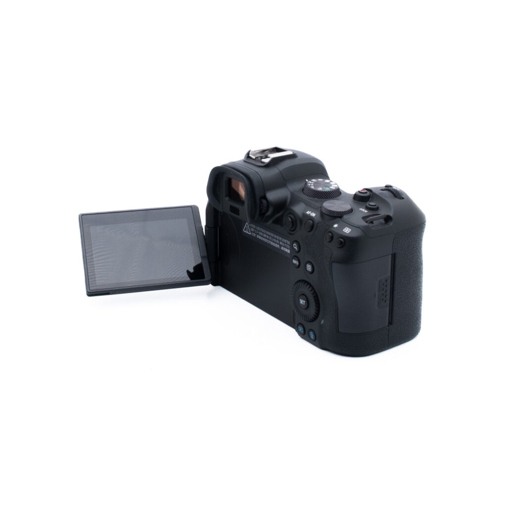 Canon R6 3546-3 Digitaalikamera, jossa on ulos käännettävä nestekidenäyttö, näkyy valkoisella pohjalla takaa ja hieman sivulta katsottuna, ja siinä on erilaisia painikkeita ja säätimiä.