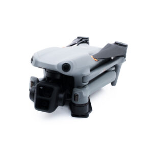 DJI Air 3-6 Pienikokoinen, kokoontaitettu harmaa lennokki, jossa on mustat potkurit ja etukamera valkoisella pohjalla.