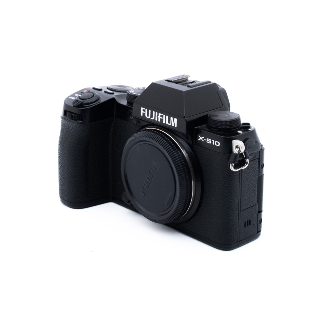 Fuji X-S10-5-3 Musta Fujifilm X-S10 -digitaalikameran runko näkyy valkoisella pohjalla, ja se on suunnattu siten, että kahva, säätimet ja objektiivin kiinnitys näkyvät ilman kiinnitettyä objektiivia.