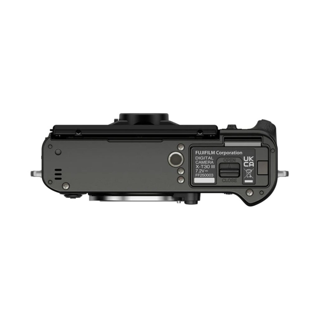 FujiX-T30IIIHarmaa3 Fujifilm X-T30 III Body Harmaa (Charcoal Silver) -rungon ylhäältä katsottuna, jossa korostuvat objektiivin kiinnitys, akkulokero, etiketit sekä useat portit ja säätimet valkoisella taustalla.
