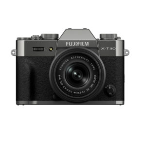 FujiX-T30IIIGreyLens1 Front view of a grey Fujifilm X-T30 III camera with black textured grip and attached XC 13-33mm f/3.5-6.3 OIS lens with top dials and Fujifilm branding above the lens.
