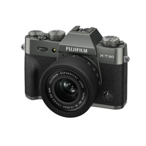 FujiX-T30IIIHarmaaLinssi2 Harmaa Fujifilm X-T30 III -digitaalikamera, jossa on XC 13-33mm f/3.5-6.3 OIS -objektiivi, näkyy kuvakulmassa valkoista taustaa vasten.