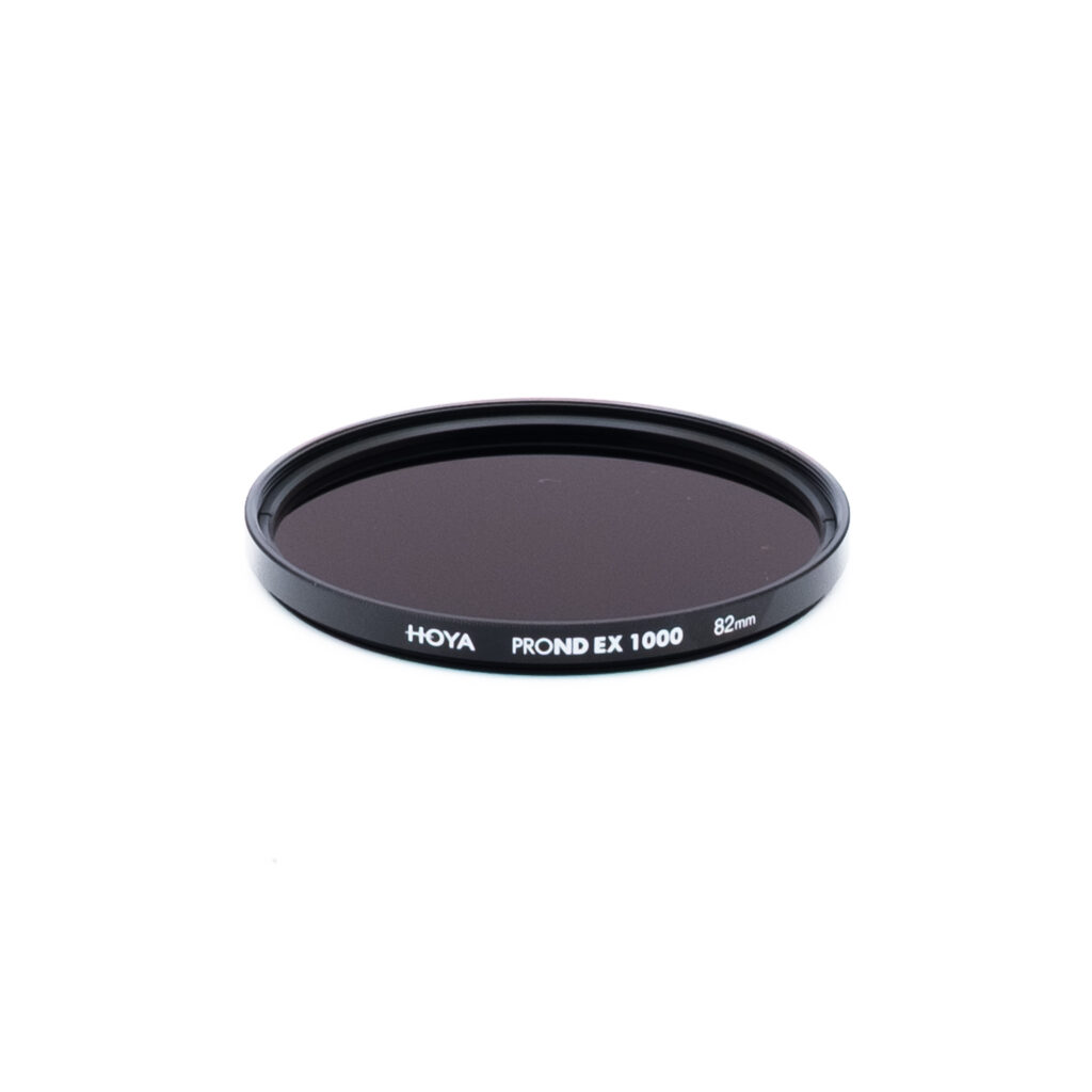 Hoya ND1000 82mm Pyöreä Hoya PROND EX 1000 -kameran linssisuodatin, halkaisijaltaan 82 mm, tummalla sävytetyllä lasilla ja mustalla kehyksellä, kuvassa valkoisella pohjalla.