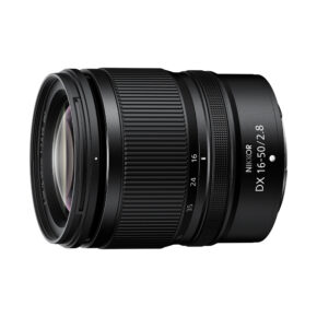 NikkorDX16-50 Nikon Nikkor Z DX 16-50mm f/2.8 VR -objektiivi näkyy vinossa valkoisella taustalla, jossa korostuvat objektiivin lasi, tarkennusrengas ja tynnyrin merkintä.