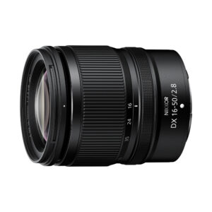 NikkorDX16-50 Nikon Nikkor Z DX 16-50mm f/2.8 VR -objektiivi näkyy vinossa valkoisella taustalla, jossa korostuvat objektiivin lasi, tarkennusrengas ja tynnyrin merkintä.