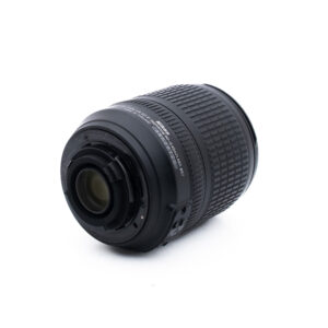 Nikon 18-105mm f35-56 G ED DX VR-1 Musta kameran objektiivi on kyljellään valkoista taustaa vasten, ja siinä näkyy takakiinnitys ja kuvioitu zoomausrengas.
