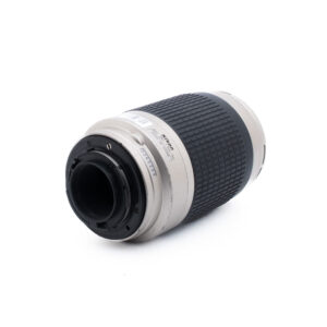Nikon AF Nikkor 70-300mm f4-56 G-1 Nikon-kameran objektiivi, jossa on hopeanvärinen ja musta runko, kuvassa kyljellään siten, että kiinnityspää osoittaa eteenpäin, ja siinä näkyvät objektiivin koskettimet ja bajonettikiinnitys.
