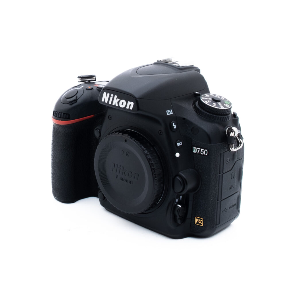 Nikon D750 5512-5 Musta Nikon D750 DSLR -kameran runko, jossa on objektiivin suojus, hieman vasemmalle kallistettu, ja jossa on erilaisia painikkeita ja valitsimia valkoisella taustalla.
