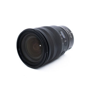 Nikon Z 24-70mm f28 S-2-2 Musta kameran zoom-objektiivi, jossa on uurteiset tarkennus- ja zoomausrenkaat ja jossa on merkintä "24-70mm 1:2.8 S", on kuvattu kulmassa valkoisella pohjalla.